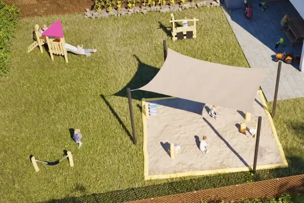 Ein zur Kinderkrippe umfunktioniertes Reihenhaus mit Garten. Im Garten mehrere Robinienspielgeräte