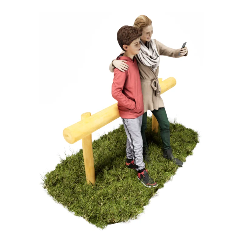 Anlehnbank aus einem Robinien-Stammrahmen für Erwachsene. Eine Mutter lehnt sich mit ihrem Sohn an während sie ein Selfie machen