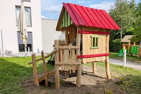 Rückansicht auf ein Stelzenhaus in einer Großstadt-Kinderkrippe. auf Wiese in einem Innenhof